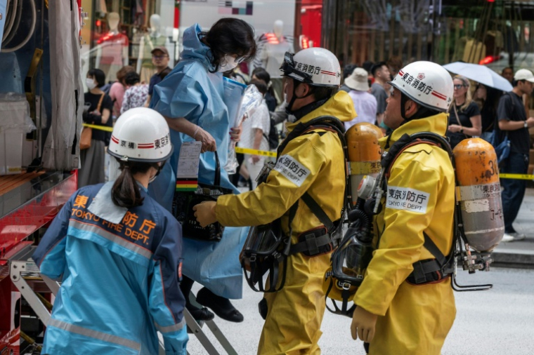 Les secours aident une femme qui était dans un centre commercial quand un homme y a pulvérisé une substance, à Tokyo, le 25 mai 2026 ( AFP / Andrew CABALLERO-REYNOLDS )