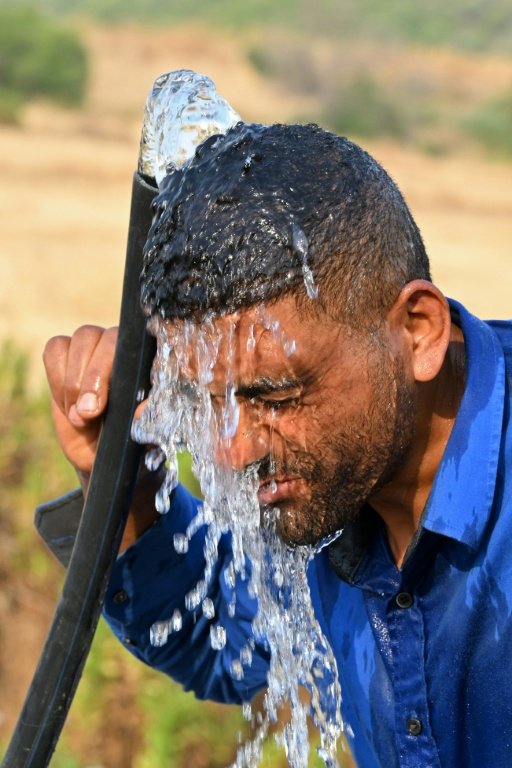 Un homme se rafraîchit à l'eau lors d'une journée de forte chaleur près de Bizerte, dans le nord de la Tunisie, le 21 juillet 2026 ( AFP / FETHI BELAID )