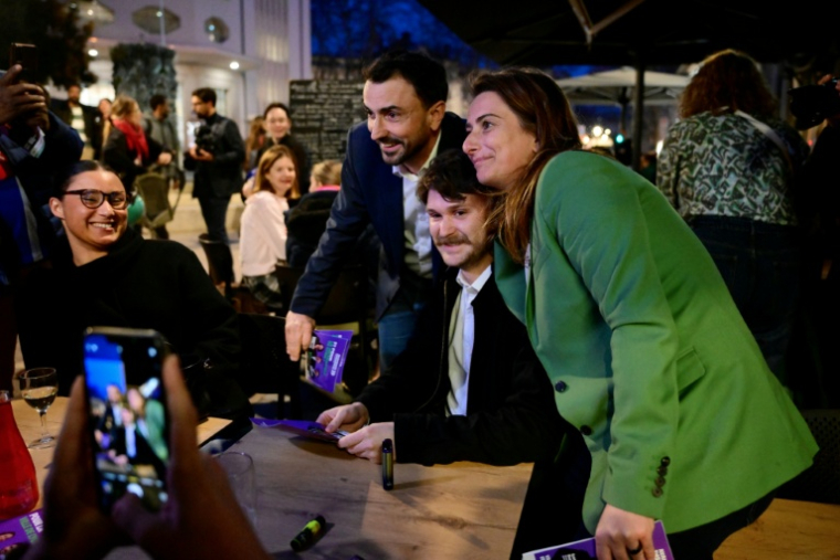 Le maire de Lyon Grégory Doucet (2e g), candidat à sa réélection aux municipales, et la secrétaire nationale des Écologistes, Marine Tondelier (d), posent pour des photos lors d'une distribution de tracts à Lyon, le 5 mars 2026 ( AFP / Olivier CHASSIGNOLE )