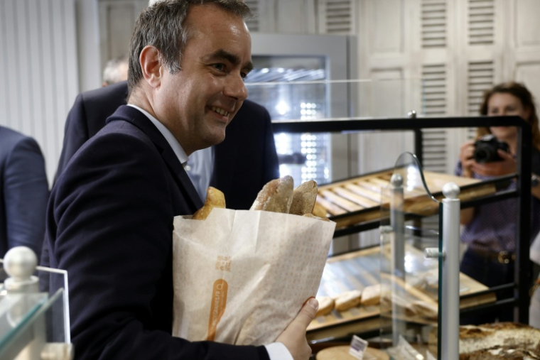 Le Premier ministre Sébastien Lecornu achète du pain dans une boulangerie à l'occasion de la Fête du Travail à Saint-Julien-Chapteuil, le 1er mai 2026 en Haute-Loire ( AFP / Kenzo TRIBOUILLARD )