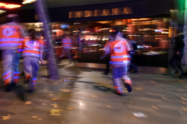 Des membres de la Croix-Rouge courent après avoir entendu des déflagrations près de la place de la République à Paris, le 13 novembre 2015 ( AFP / DOMINIQUE FAGET )