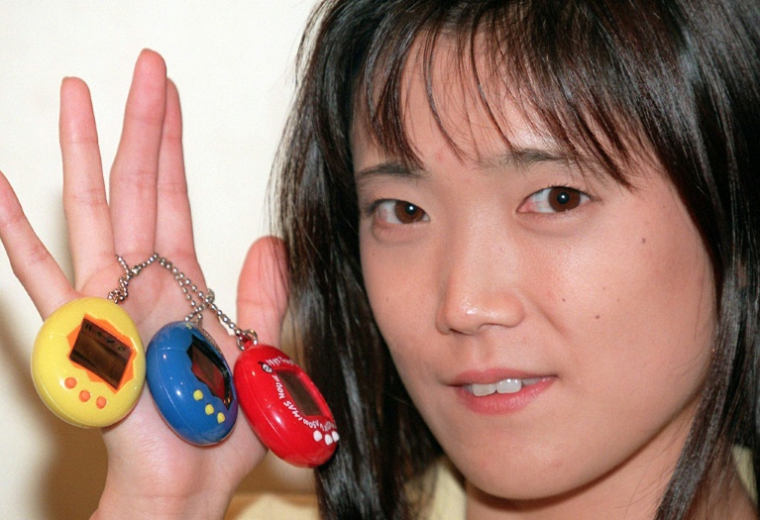 La créatrice pour le groupe japonais Bandai des Tamagotchis, Aki Maita, en présente des exemplaires le 25 août 1997 à Tokyo ( AFP / YOSHIKAZU TSUNO )