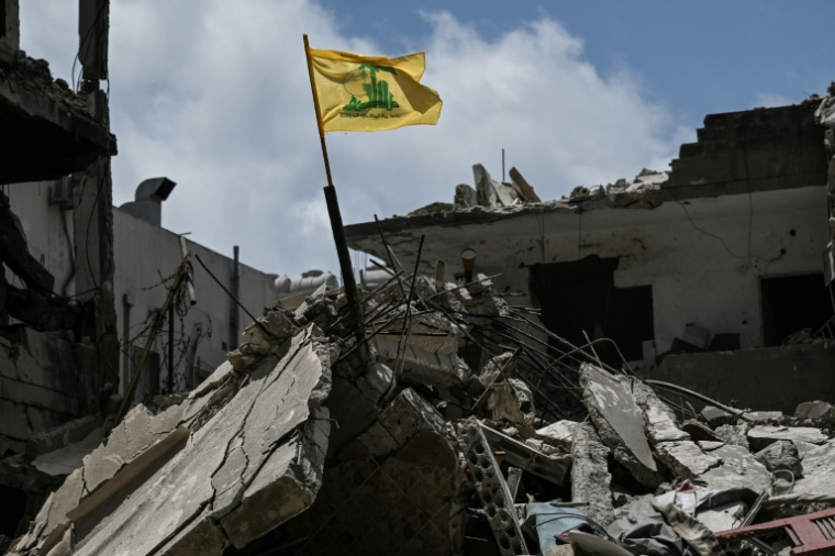 Le drapeau jaune du Hezbollah dans les décombres d'un bâtiment détruit par une frappe aérienne israélienne à Tyr, dans le sud du Liban, le 23 juin 2026 ( AFP / Joseph EID )