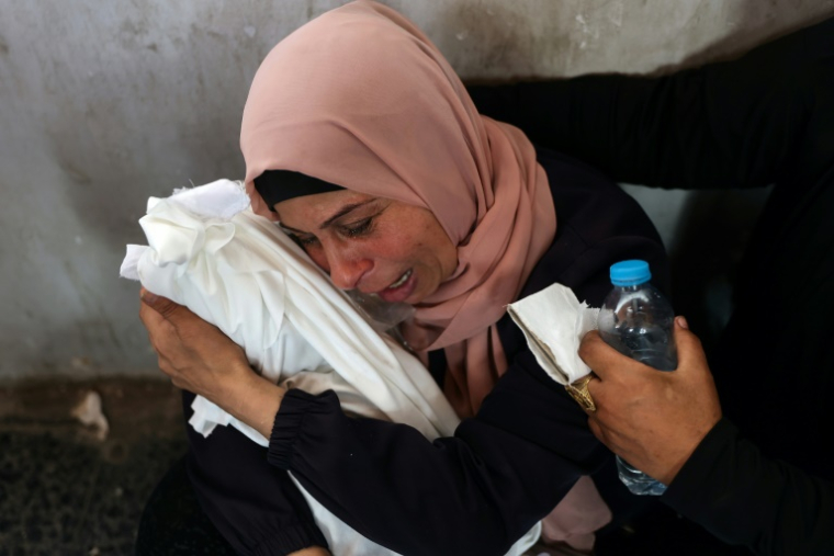 Une Palestinienne pleure en tenant le corps enveloppé d'un bébé tué dans une frappe israélienne selon les secours locaux sur le quartier de Choujaïya à Gaza-ville, le 9 avril 2025 ( AFP / Omar AL-QATTAA )