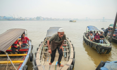 Des bateaux de passagers attendent de traverser la rivière Musi à Palembang, dans le sud de Sumatra, dans un épais brouillard causé par les fumées d'incendies, le 22 septembre 2026 ( AFP / AL ZULKIFLI )