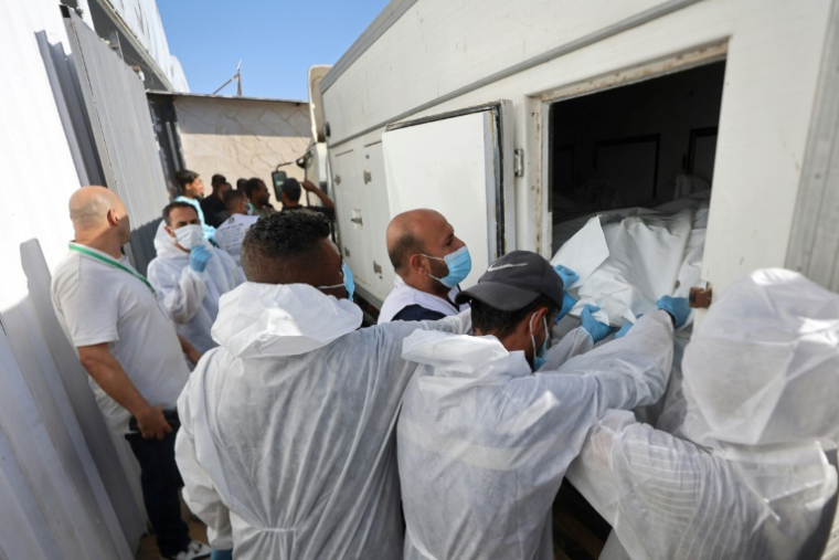 Des employés de la morgue déchargent les corps de Palestiniens qui étaient détenus par Israël, après leur transport par des véhicules du Croissant-Rouge et des camions frigorifiques, à l’hôpital Nasser de Khan Younès, dans le sud de la bande de Gaza, le 15 octobre 2025 ( AFP / Omar AL-QATTAA )