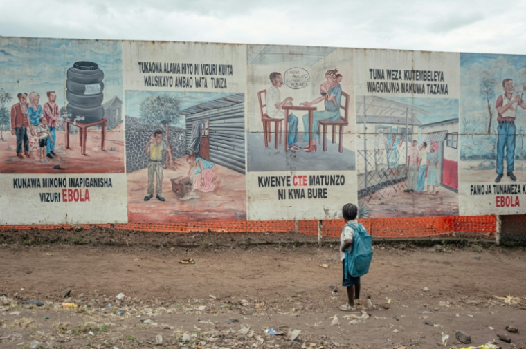 Un enfant devant des affiches de prévention contre Ebola à Munigi en République démocratique du Congo le 2 juin 2026 ( AFP / Jospin Mwisha )