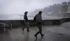 Des promeneurs pris dans les bourrasques de la tempête Austen sur le front de mer à Granville, dans la Manche, le 23 octobre 2026 ( AFP / Guillaume SALIGOT )