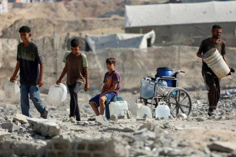 Des enfants palestiniens viennent s'approvisionner en eau à un point de distribution de Khan Younès, dans le sud de la bande de Gaza, le 24 septmbre 2025 ( AFP / Omar AL-QATTAA )