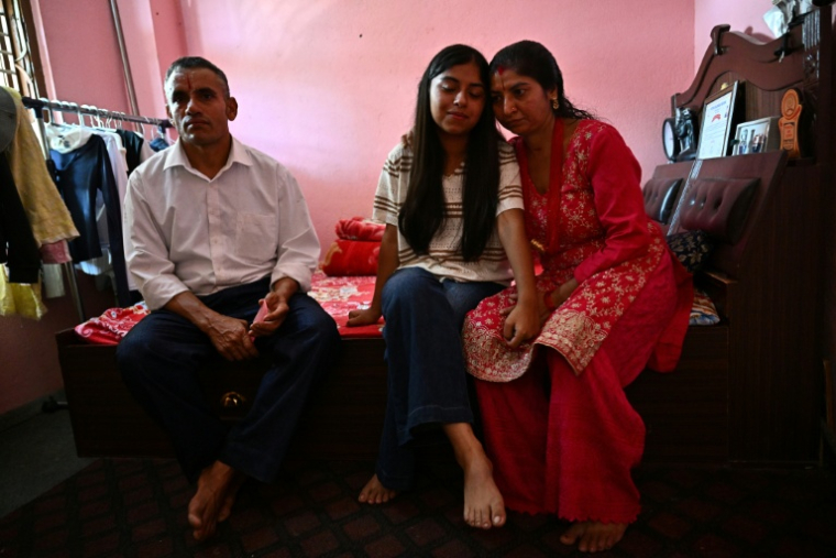 Santoshi Dotel (au centre) et ses parents, Raj Kumar Dotel (à gauche) and Durga Dotel, dans leur maison à Trishuli Bazar, Népal, le 5 septembre 2026 ( AFP / Pedro PARDO )