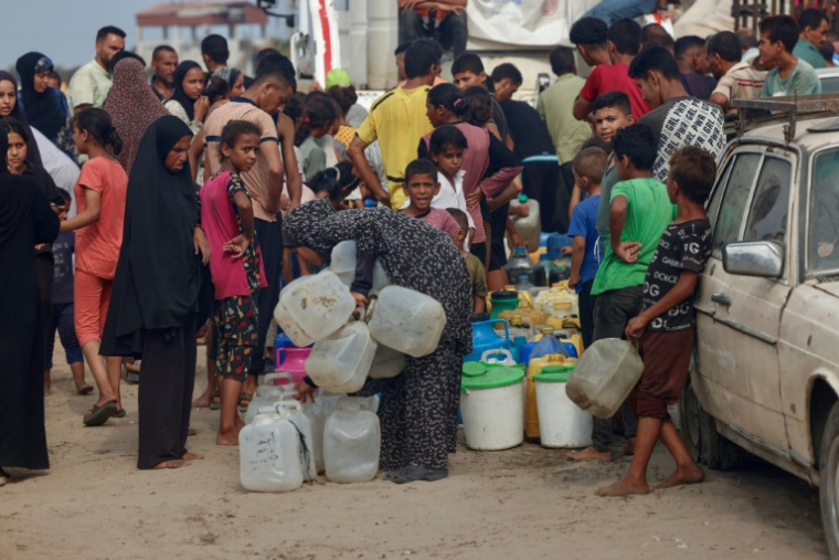 Des Palestiniens font la queue pour remplir des bidons d'eau, à al-Mawasi, dans le sud de la bande de Gaza, le 12 août 2025 ( AFP / - )