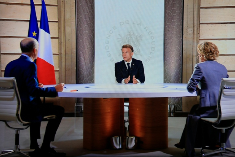 Un écran de contrôle montre le président Emmanuel Macron (c) s'exprimant lors d'un entretien avec la journaliste de France 2 Caroline Roux (d) et le journaliste de TF1 Gilles Bouleau (g) à l'Élysée, à Paris, le 24 septembre 2026 ( AFP / Ludovic MARIN )