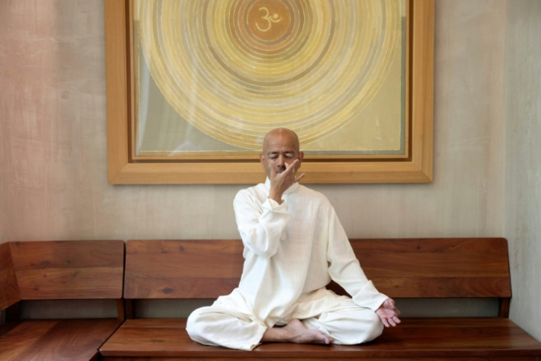 Varun Veer (g), fondateur de Lifeyoga, fait une démonstration de "Pranayama" lors d'une séance dans son studio de New Delhi, le 19 juin 2026 en Inde ( AFP / Arun SANKAR )