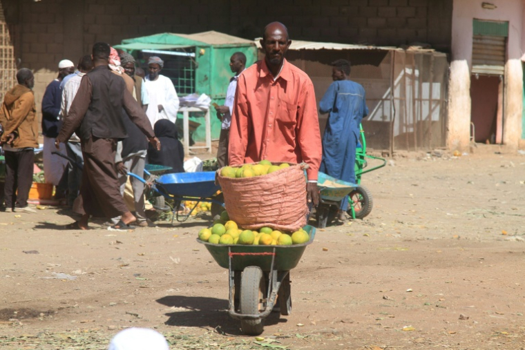 Un vendeur de fruits transporte des oranges, le 17 janvier 2025 à Khartoum au Soudan ( AFP / Ebrahim HAMID )