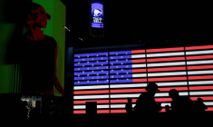 Des silhouettes devant le drapeau américain à New York