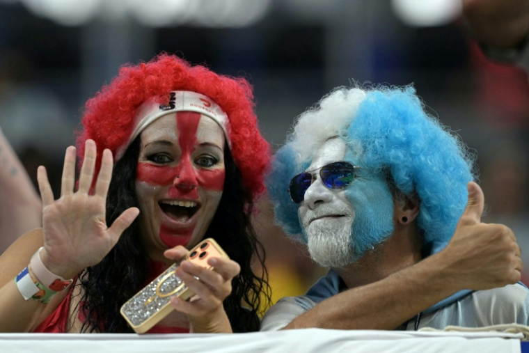 Une supportrice aux couleurs de l'Angleterre et un fan de l'Argentine prennent la pose à quelques heures du coup d'envoi de la seconde demi-finale du Mondial-2026 le 15 juillet 2026 à Atlanta ( AFP / JUAN MABROMATA )