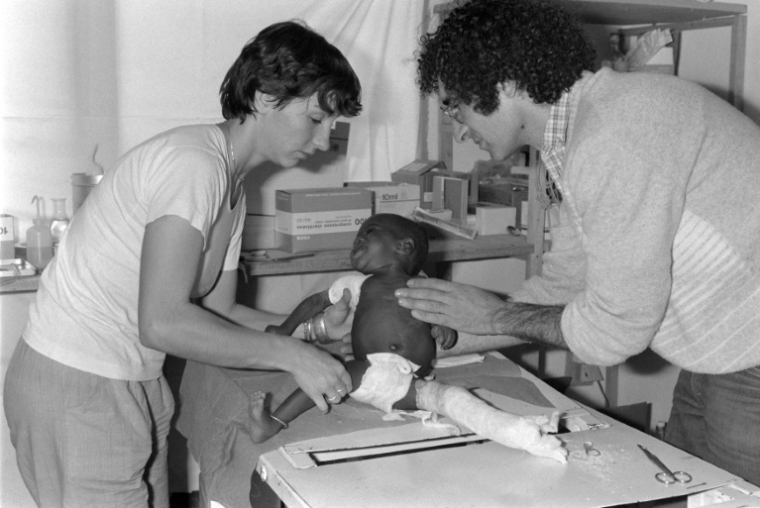 Xavier Emmanuelli et une autre médecin de Médecins sans Frontieres s'occupent d'un petit enfant à N'Djamena, a Tchad, le 1er décembre 1981 ( AFP / DOMINIQUE FAGET )