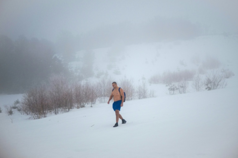 L'archéologue serbe Vladimir Stevanovic marche dans une épaisse couche de neige, en short et chaussures de randonnée, sur le mont Besna Kobila, près de la ville de Vranje, le 30 janvier 2026 en Serbie ( AFP / Oliver BUNIC )