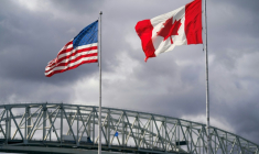 Les drapeaux américain et canadien près du poste frontalier du pont Blue Water à Point Edward, en Ontario, le 24 octobre 2025 au Canada ( AFP / Geoff Robins )