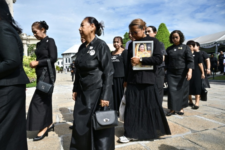 Des personnes en deuil arrivent au Grand Palais pour rendre hommage à la princesse défunte Bajrakitiyabha Mahidol, le 13 juin 2026 à Bangkok ( AFP / ANTHONY WALLACE )