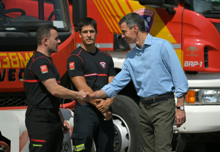 Le Premier ministre espagnol Pedro Sánchez (d), salue des membres des services de secours à son arrivée dans la zone d'un incendie de forêt meurtrier, au poste de commandement à Turre, dans la province d'Almería, le 13 juillet 2026 en Espagne ( AFP / JORGE GUERRERO )