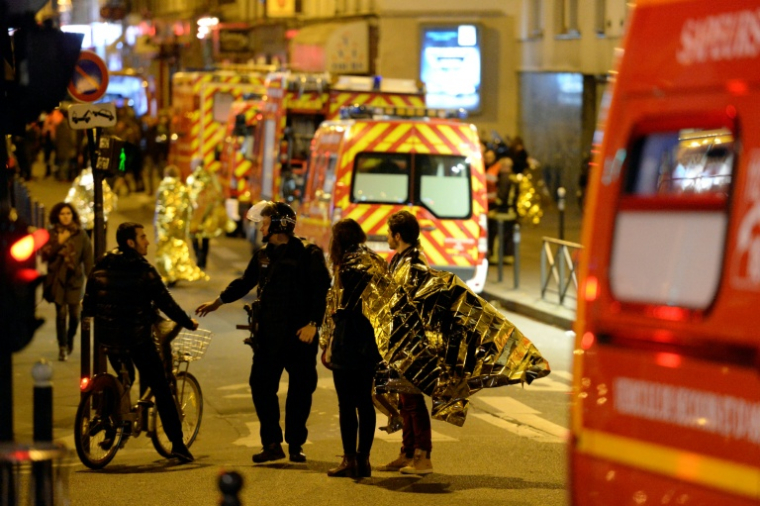 Des personnes rue Oberkampf, près de la salle de concert du Bataclan ciblée par une attaque jihadiste meurtrière, sont évacuées par les forces de police dans la nuit du 13 au 14 novembre 2015 à Paris ( AFP / Miguel MEDINA )