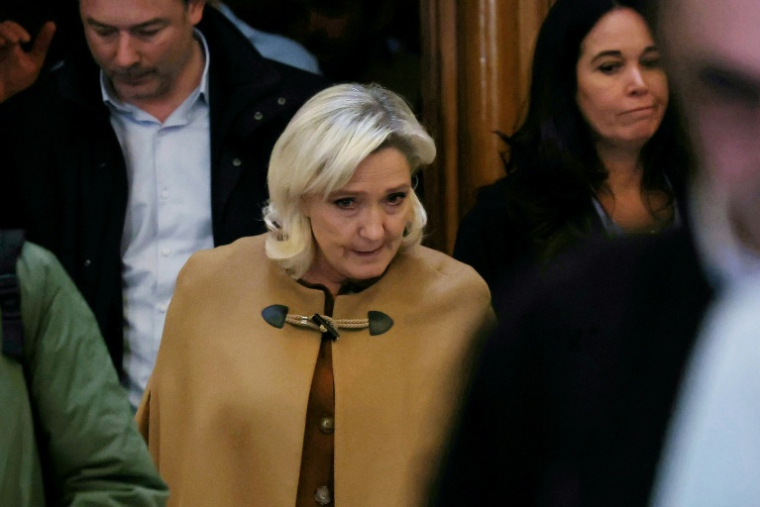 President of the parliamentary group of the French far-right Rassemblement National (RN) party, Marine Le Pen (C) leaves after a break during her appeal trial on charges of embezzlement of European public funds in a case of alleged European Parliament fake jobs at the Palais de Justice in Paris on February 3, 2026. Le Pen is called to the stand in the appeal trial in Paris of the parliamentary assistants of the National Front, where she is playing for her candidacy for the 2027 presidential election. Twelve of the accused, as well as the far-right party itself, have appealed against the verdict while another 12 people -- including one of Le Pen's sisters -- have decided to accept their convictions without appealing. The public prosecutor's office is expected to announce its charges against Marine Le Pen, the National Rally party, and ten party officials on February 3, 2026. ( AFP / Thomas SAMSON )