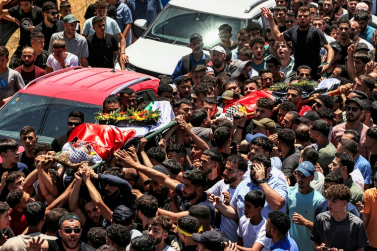 Les corps de Seif Musallet, un Américano-Palestinien de 20 ans, et de Mohammed al-Shalabi, un Palestinien de 23 ans, portés par la foule le jour de leurs funérailles, à Al-Mazra'ah ash Sharqïyah, en Cisjordanie occupée, le 13 juillet 2025 ( AFP / Zain JAAFAR )
