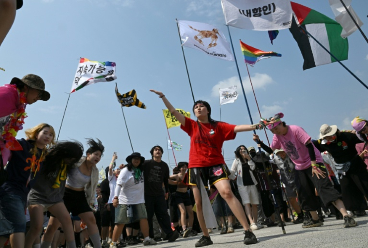Des spectateurs dansent lors du concert du groupe de rock Peach Truck Hijackers au DMZ Peace Train Festival, le 14 juin 2026 à Cheorwon, en Corée du Sud, près de la frontière avec la Corée du Nord  ( AFP / Jung Yeon-je )