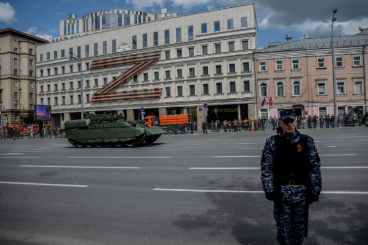 Un véhicule militaire passe devant une lettre Z géante, insigne tactique des troupes russes en Ukraine, avant la répétition générale du défilé militaire du Jour de la Victoire, le 7 mai 2025 à Moscou ( AFP / Angelos TZORTZINIS )