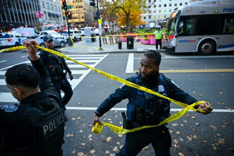 Des policiers établissent un périmètre autour de la scène de crime après l'attaque par balles de deux soldats de la Garde nationale, le 26 novembre 2025 à Washington ( AFP / Drew ANGERER )