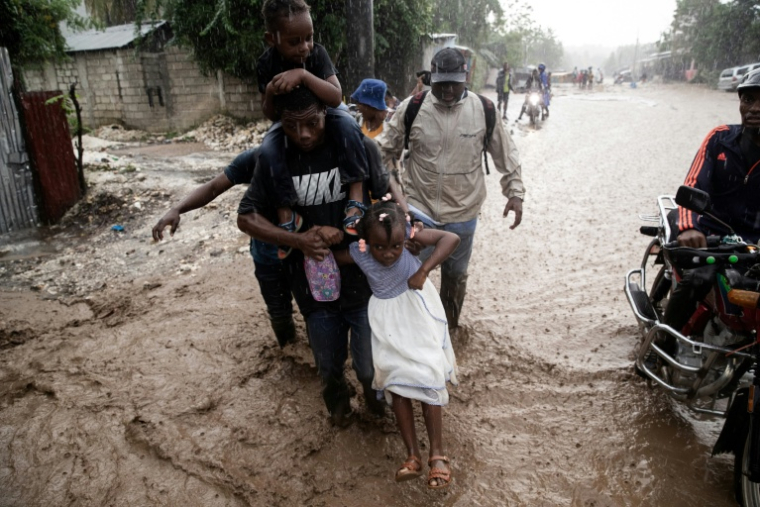 Des personnes marchent dans une rue inondée à la suite de l'ouragan Melissa à Petit-Goave, à 68km au sud-ouest de Port-au-Prince, en Haïti, le 30 octobre 2025 ( AFP / Clarens SIFFROY )