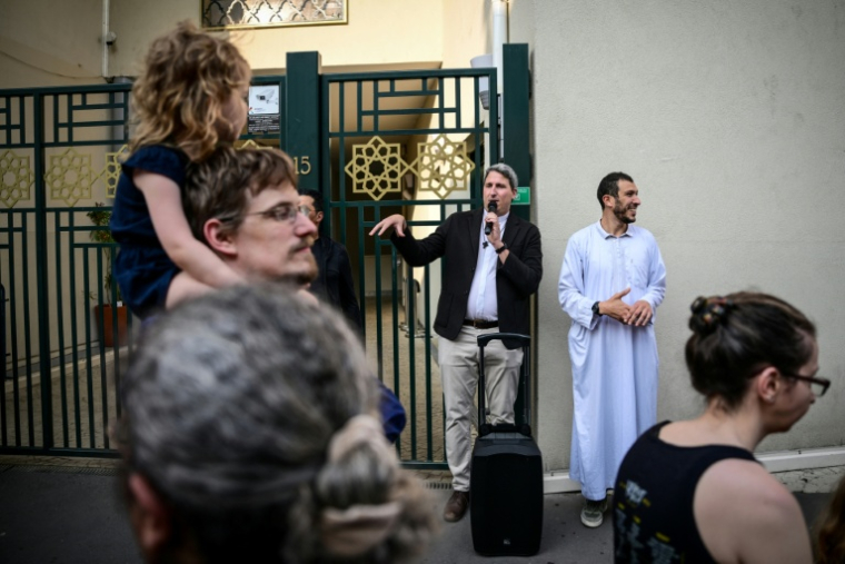 Thierry Brac de la Perrière, prêtre de Notre-Dame-de-la-Fraternité (au centre) et le secrétaire de la mosquée Errahma, Nabil Bouslama (à droite), devant la mosquée, le 9 juin 2025 ( AFP / OLIVIER CHASSIGNOLE )