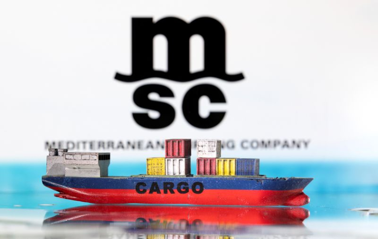Une maquette de porte-conteneurs devant le logo de la Mediterranean Shipping Company (MSC)