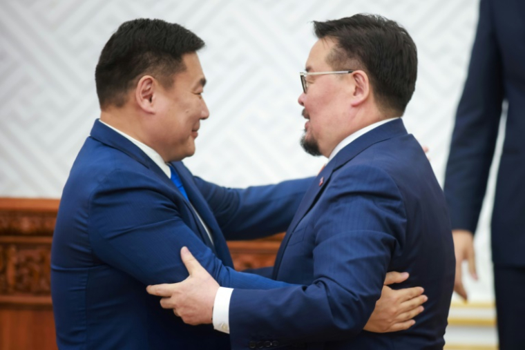 Le nouveau Premier ministre mongol Gombojav Zandanshatar (à droite) est félicité par son prédécesseur Luvsannamsrain Oyun-Erdene après un vote au Parlement à Oulan-Bator, la capitale de la Mongolie, le 13 juin 2025 ( AFP / BYAMBASUREN BYAMBA-OCHIR )