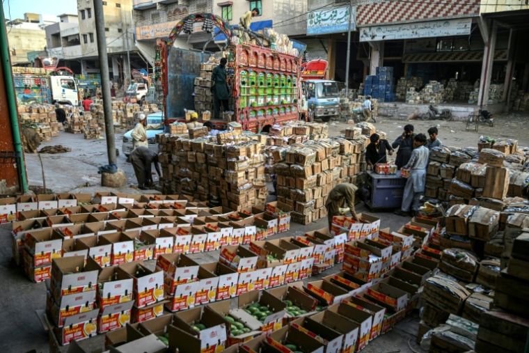 TDes ouvriers chargent des caisses de mangues sur un camion à Karachi, le 5 juin 2026 au Pakistan ( AFP / Rizwan TABASSUM )