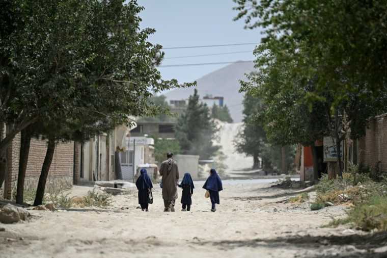 Des fillettes afghanes marchent avec leur père vers une école primaire de Kaboul, en Afghanistan, le 21 juillet 2026 ( AFP / STR )