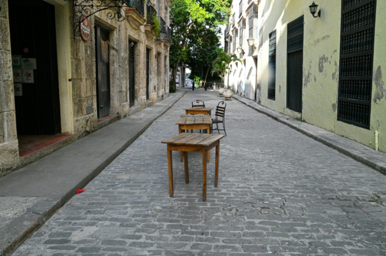 Tables et chaises de restaurants fermés dans une rue déserte de La Havane, le 21 août 2026 ( AFP / ADALBERTO ROQUE )