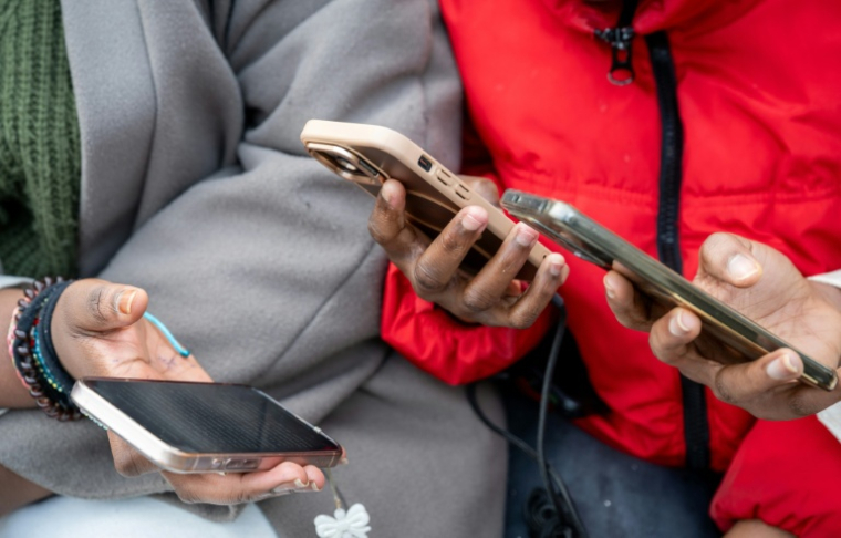 Des élèves consultent leur téléphone portable, qui seront rangés dans une mallette pendant les cours, au lycée professionnel Jean Mermoz de Montsoult, le 14 janvier 2026 dans le Val-d'Oise ( AFP / BERTRAND GUAY )