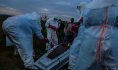 Du personnel médical en combinaison de protection enterre un patient décédé à Rwampara le 21 mai 2026 en République démocratique du Congo ( AFP / Seros MUYISA )