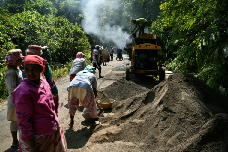 Des ouvriers attelés à la construction d'une route traversant des terres forestières dans le cadre d'un projet de grands travaux, le 26 mars 2026 près de Campbell Bay, sur l'île de Grande Nicobar, dans l'archipel indien des Andaman-et-Nicobar  ( AFP / R. Satish BABU )