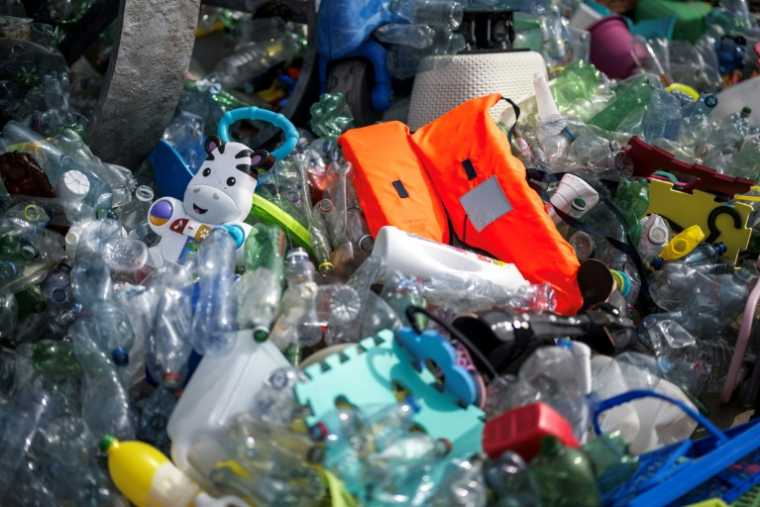 Bidons, bouteilles, filets de pêches, jouets d'enfants: toutes sortes de déchets plastiques sont utilisés par l'artiste et activiste canadien Benjamin Von Wong dans son installation intitulée "le fardeau du penseur" devant le siège de l'ONU à Genève, où se tiennent les négociations internationales sur la réduction de la pollution plastique du mardi 5 aout au jeudi 14 aout 2025 ( AFP / Fabrice COFFRINI )