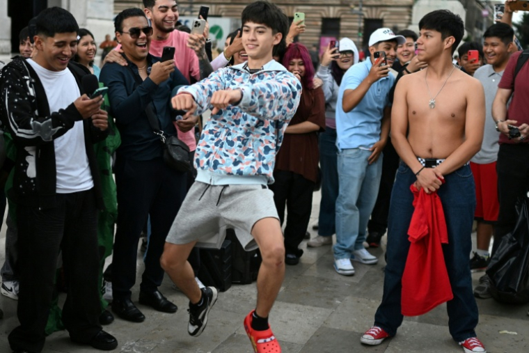 De jeunes Mexicains font des gestes en direction de leur adversaire lors d'une "bataille d'aura", à Mexico le 20 août 2026 ( AFP / Yuri CORTEZ )