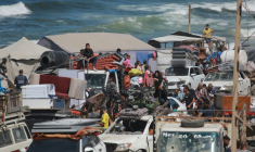 Des Palestiniens transportant leurs effets personnels traversent une route côtière au nord-ouest de Nousseirat (centre) après leur fuite de Gaza-ville, le 1er octobre 2025 ( AFP / Bashar TALEB )
