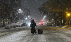 Une personne marche dans les rues enneigées de New York le 22 février 2026, aux Etats-Unis ( AFP / ANGELA WEISS )