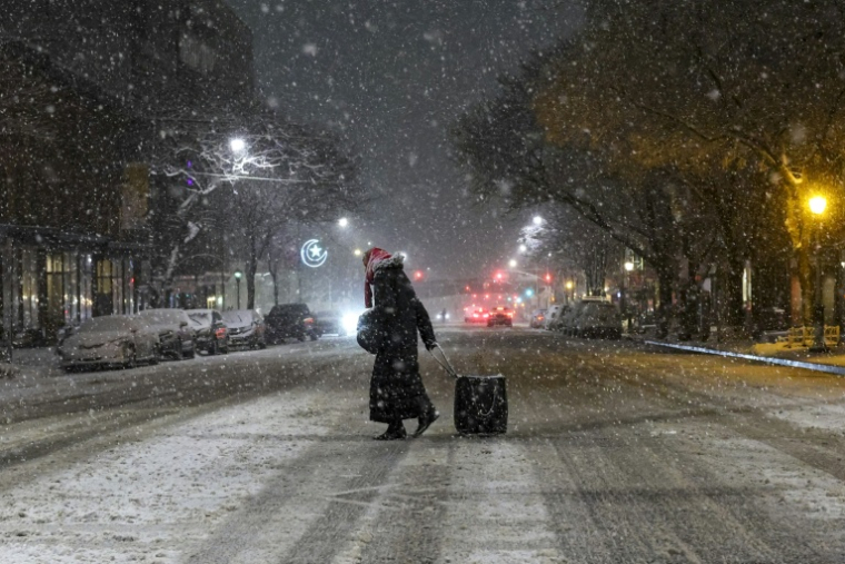 Une personne marche dans les rues enneigées de New York le 22 février 2026, aux Etats-Unis ( AFP / ANGELA WEISS )