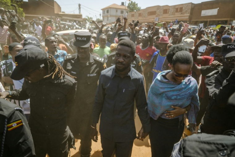 L'opposant Bobi Wine (c), candidat du Parti de l'unité nationale (NUP) à l'élection présidentielle, et son épouse Barbara Kyagulanyi (d) arrivent à Kampala pour voter lors des élections générales, le 15 janvier 2026 ( AFP / Rian COPE )