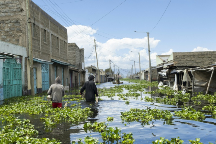 Des habitants traversent leur quartier des bords du lac Naivasha, dans le centre du Kenya, inondé par la montée des eaux, le 17 novembre 2025 ( AFP / Tony KARUMBA )