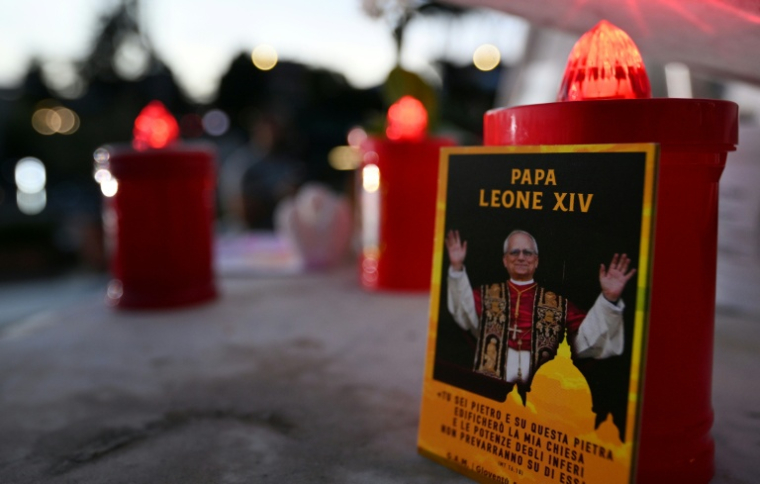 Un portrait du pape Léon XIV et des bougies déposés devant l'hôpital Gemelli où le souverain pontife est en convalescence, le 14 octobre 2026 à Rome ( AFP / Tiziana FABI )