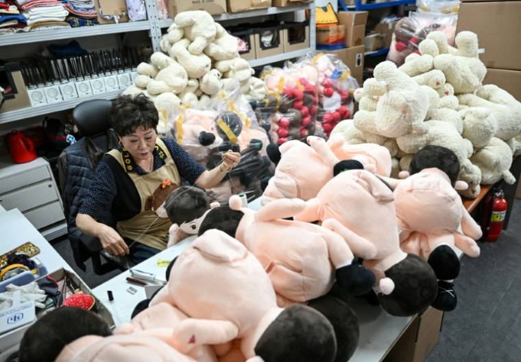 Une employée de la start-up Hyodol coud une poupée IA Hyodol, conçue pour les personnes âgées, le 6 mai 2026 au siège de l'entreprise à Anyang, en Corée du Sud  ( AFP / Jung Yeon-je )